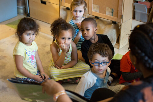 Preschool students listen to a story.