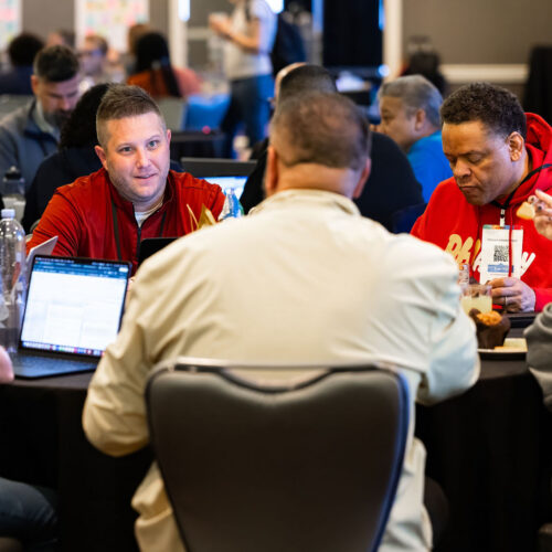 A group of adults work at a table together during an event