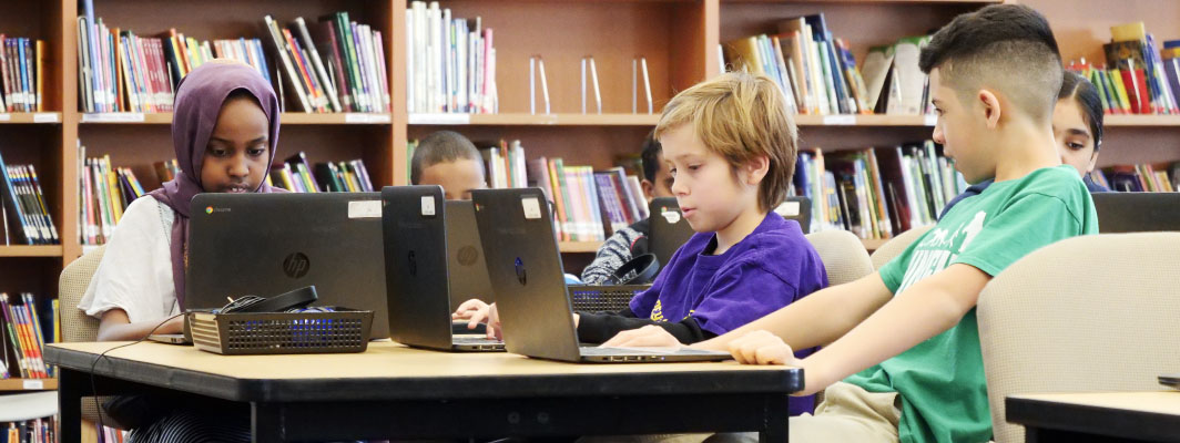 Children work on laptops
