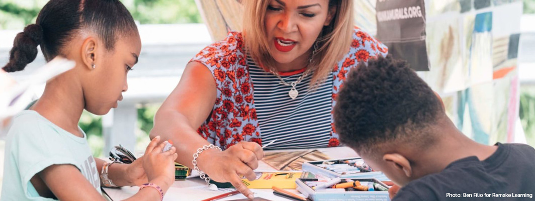 Photo of a woman of color coloring with two students of color, Ben Filio for Remake Learning
