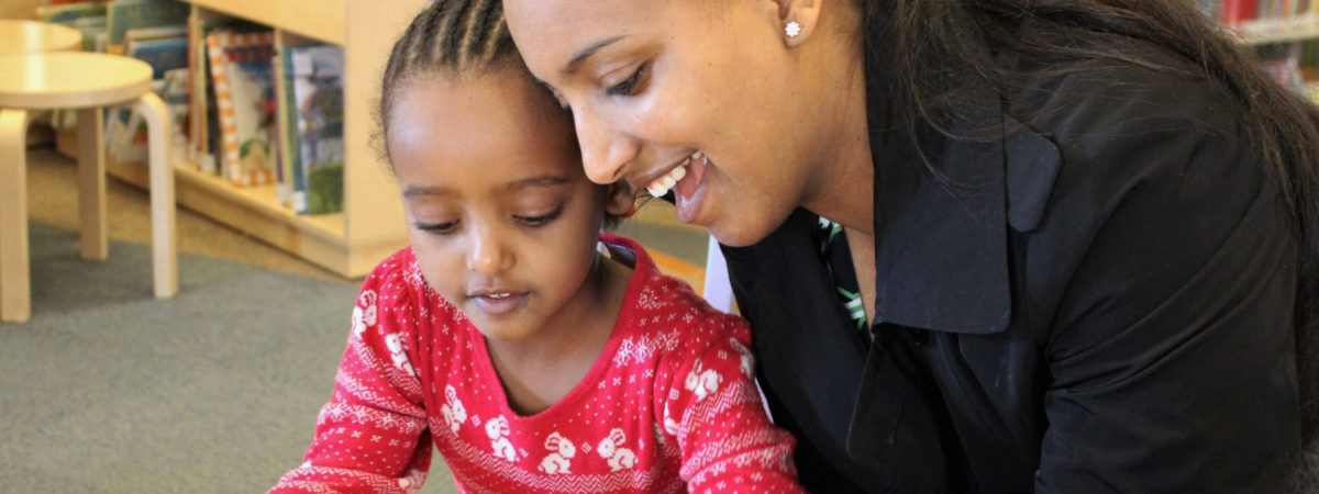 A mother and daughter work together in an elementary school classroom