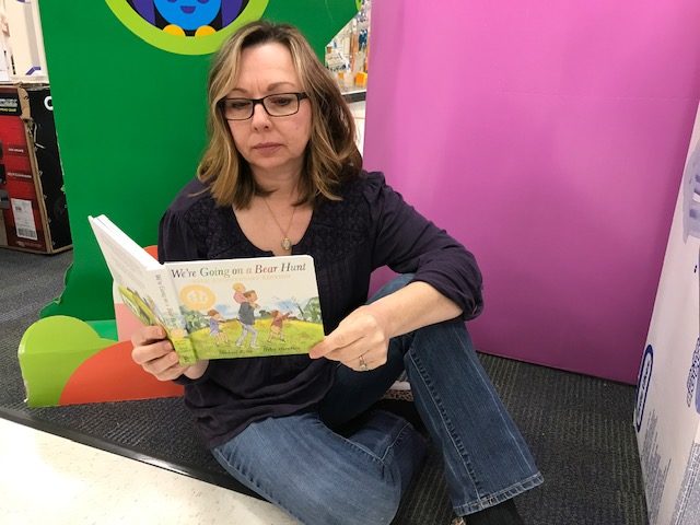 Photo of Traci Tackett reading We're Going on a Bear Hunt by Michael Rosen