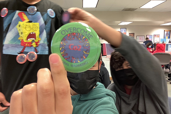 Students holding up an Overcome CO2 button