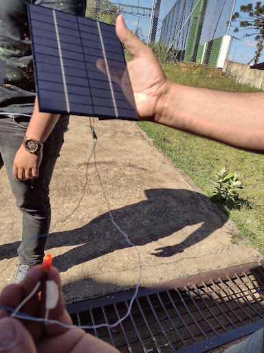 Hand holding a small solar panel.