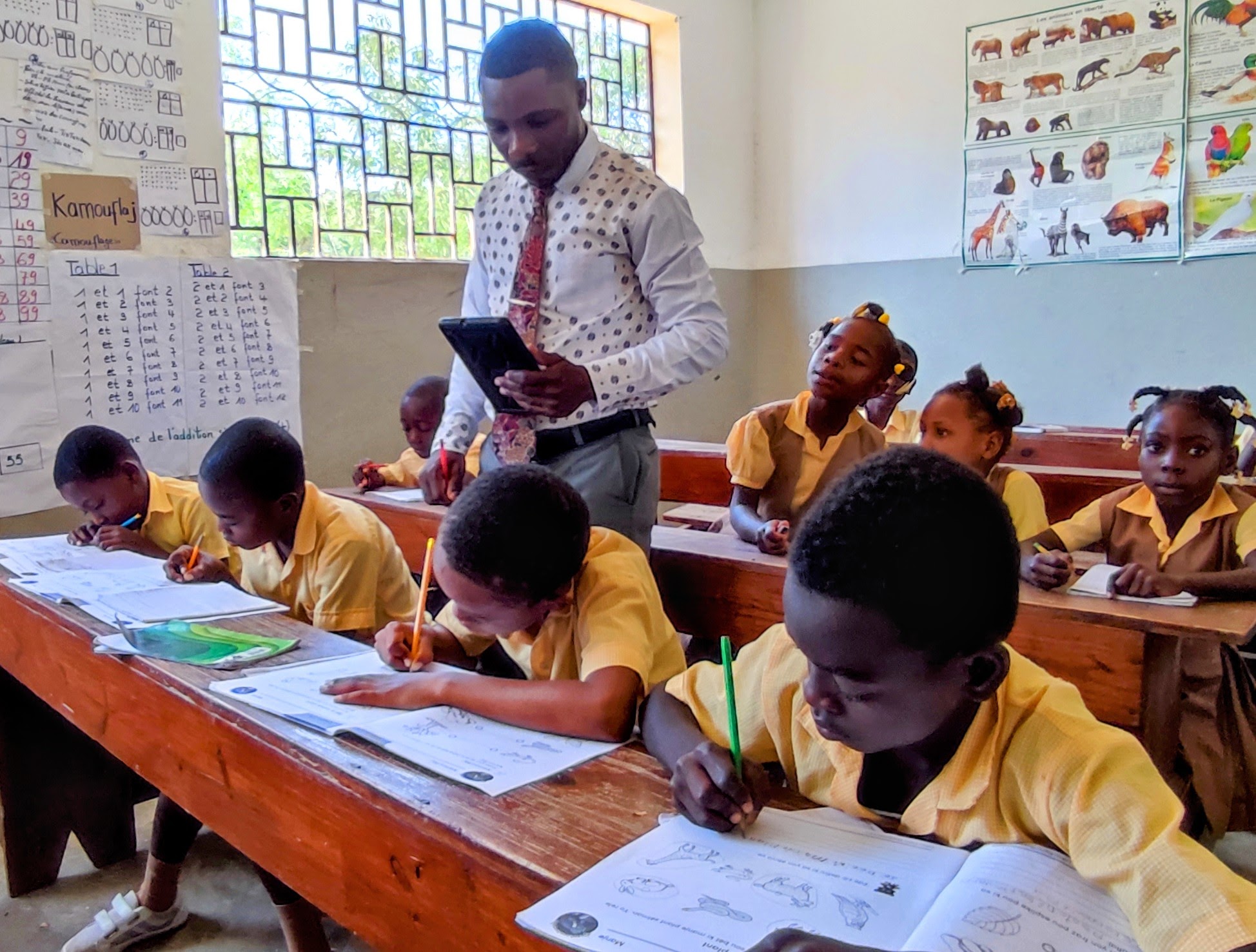 A teacher at Summits Education in Mirebalais, Haiti, works with his students on Blue Butterfly's Eksploratoryòm science education program.