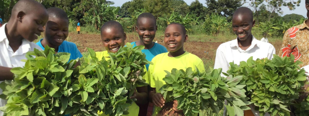 Students in Grace Nabuduwa Musingo's class in Uganda show off what they've grown in their garden