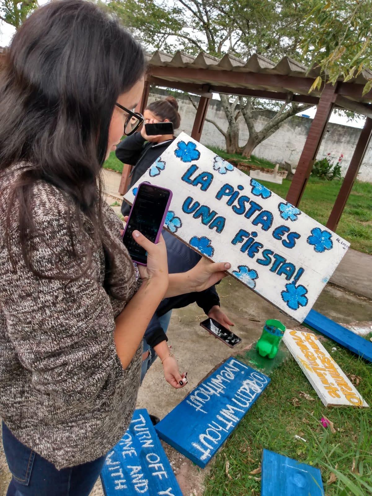 A student takes a picture of a painted sign.