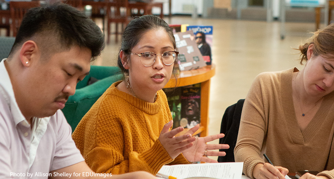 A teacher shares her thoughts during a faculty meeting.