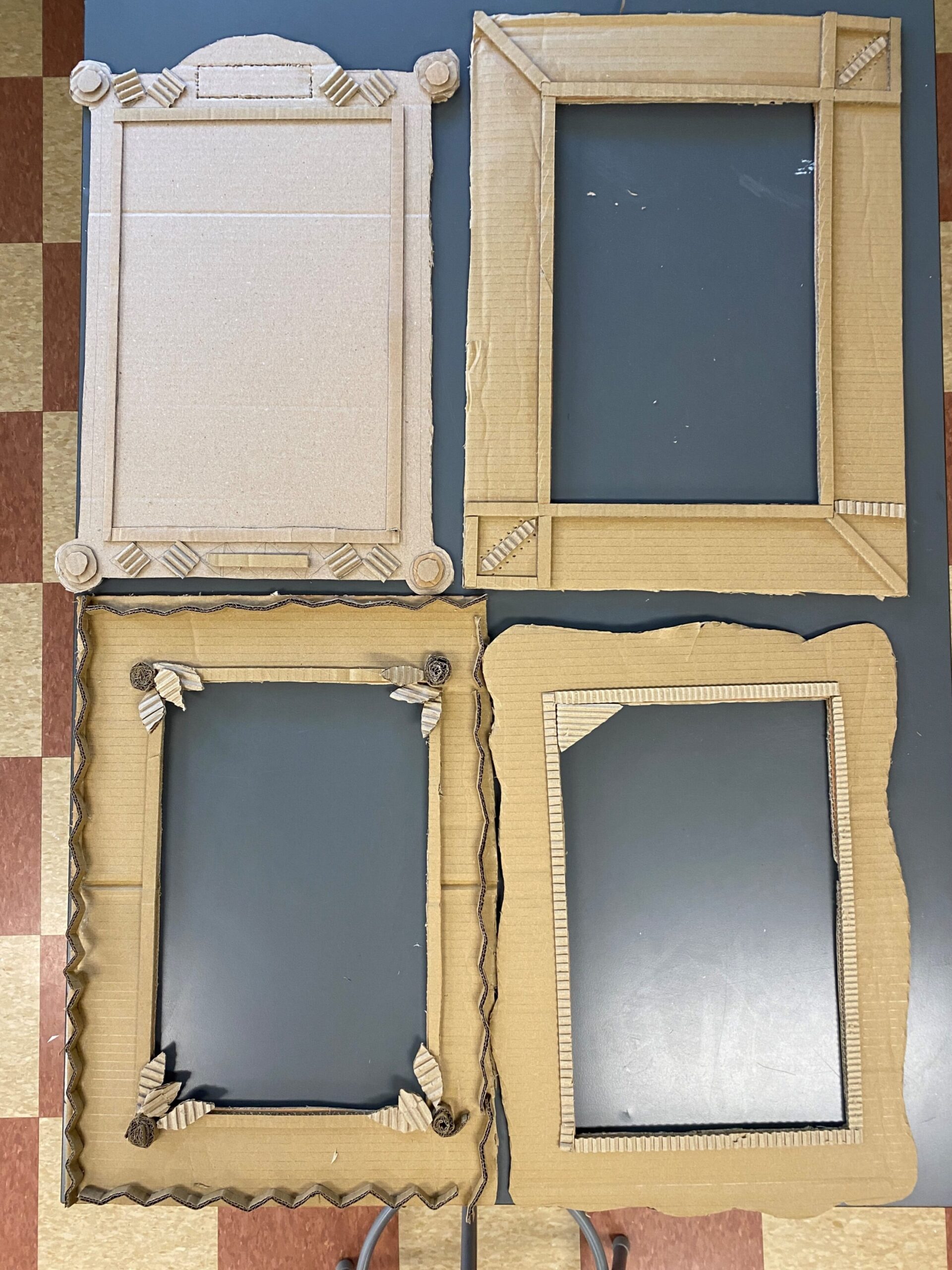 Four cardboard frames each detailed with different stylings. 
