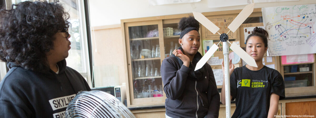 Students test a model wind turbine they constructed.
