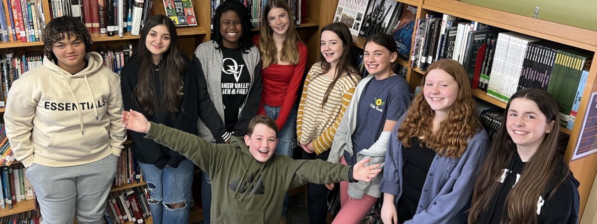 A group of 9 students line up and pose for a photo