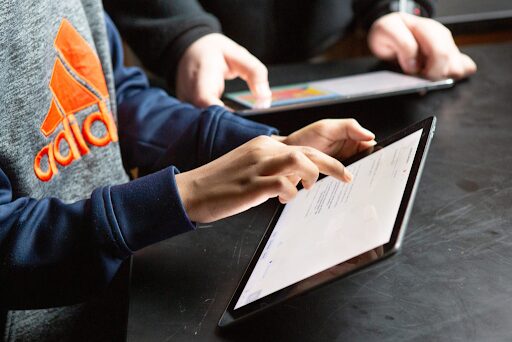 An image of two students working on their tablet computers