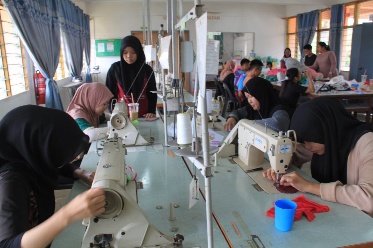 Students sew puppets at the sewing machines in their workshop. 