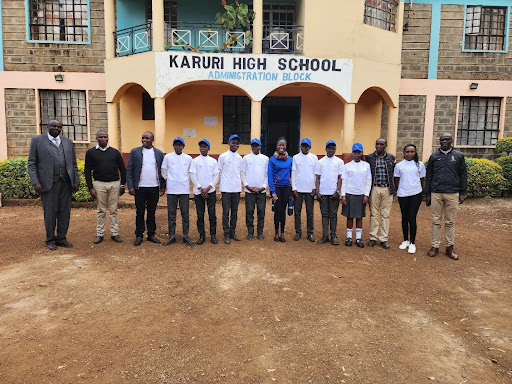 Students and educators line up in front of their high school for a picture. 