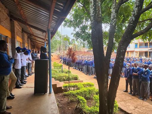 Dozens of students gather in their high school courtyard for an school assembly. 