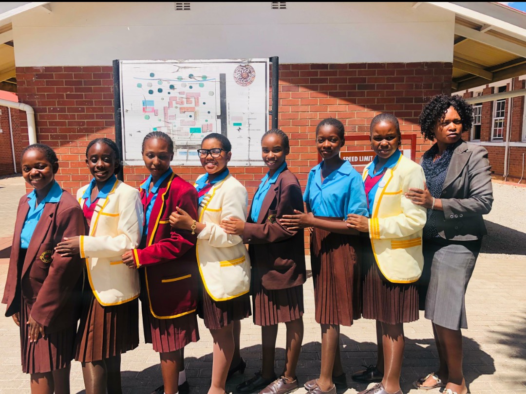 A group of students and their teacher pose for a photo