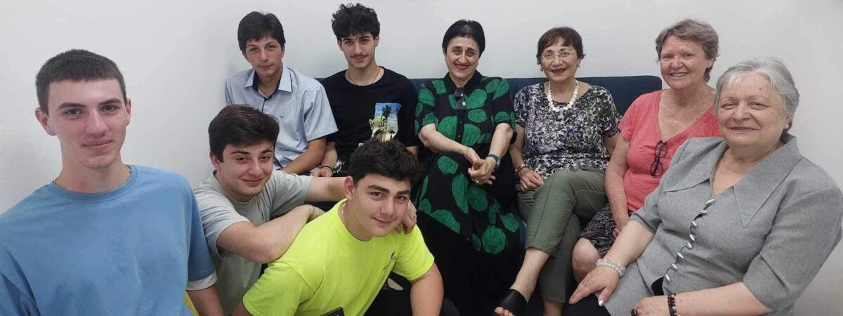 Students and teachers sit together for a photo.