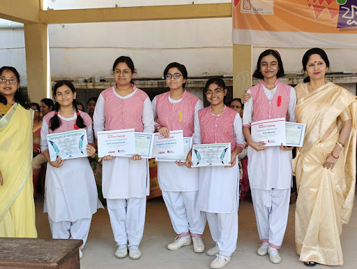 Students and their teacher pose with certificates. 