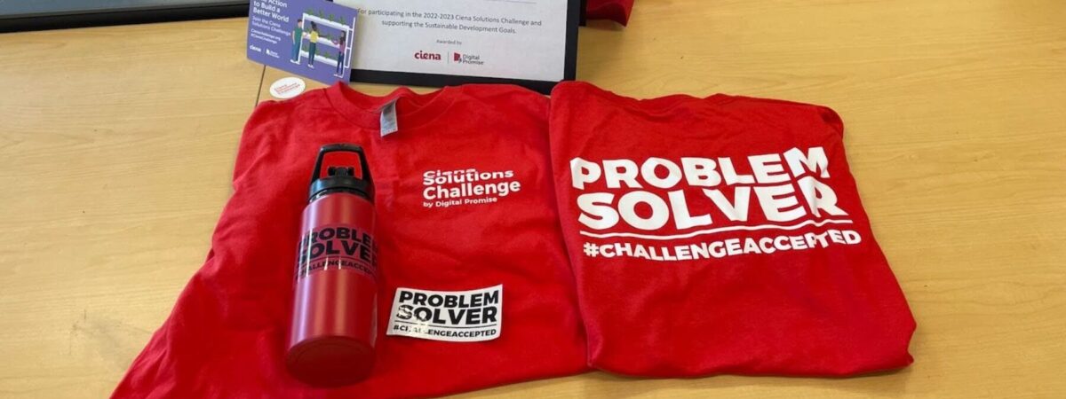 Two shirts and a water bottle that read "Problem Solver #ChallengeAccepted"