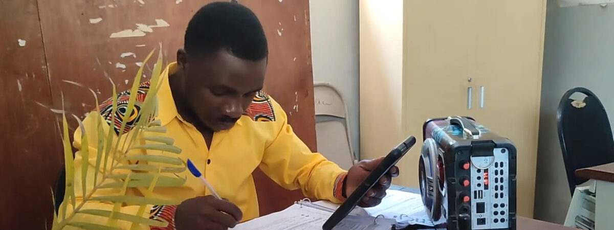 A male teacher prepares a lesson with an audio device