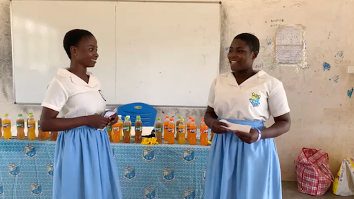 Two students present at the front of a classroom.