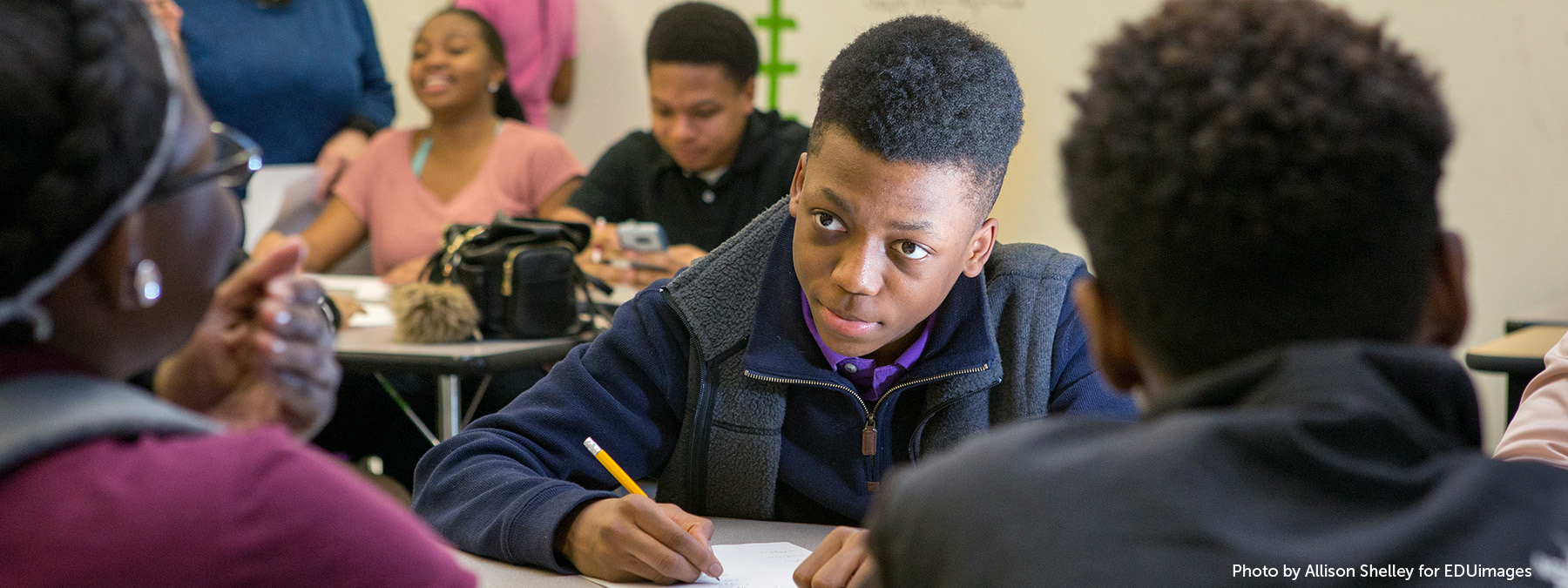 An image of ninth-grade students work together on an Algebra II assignment.