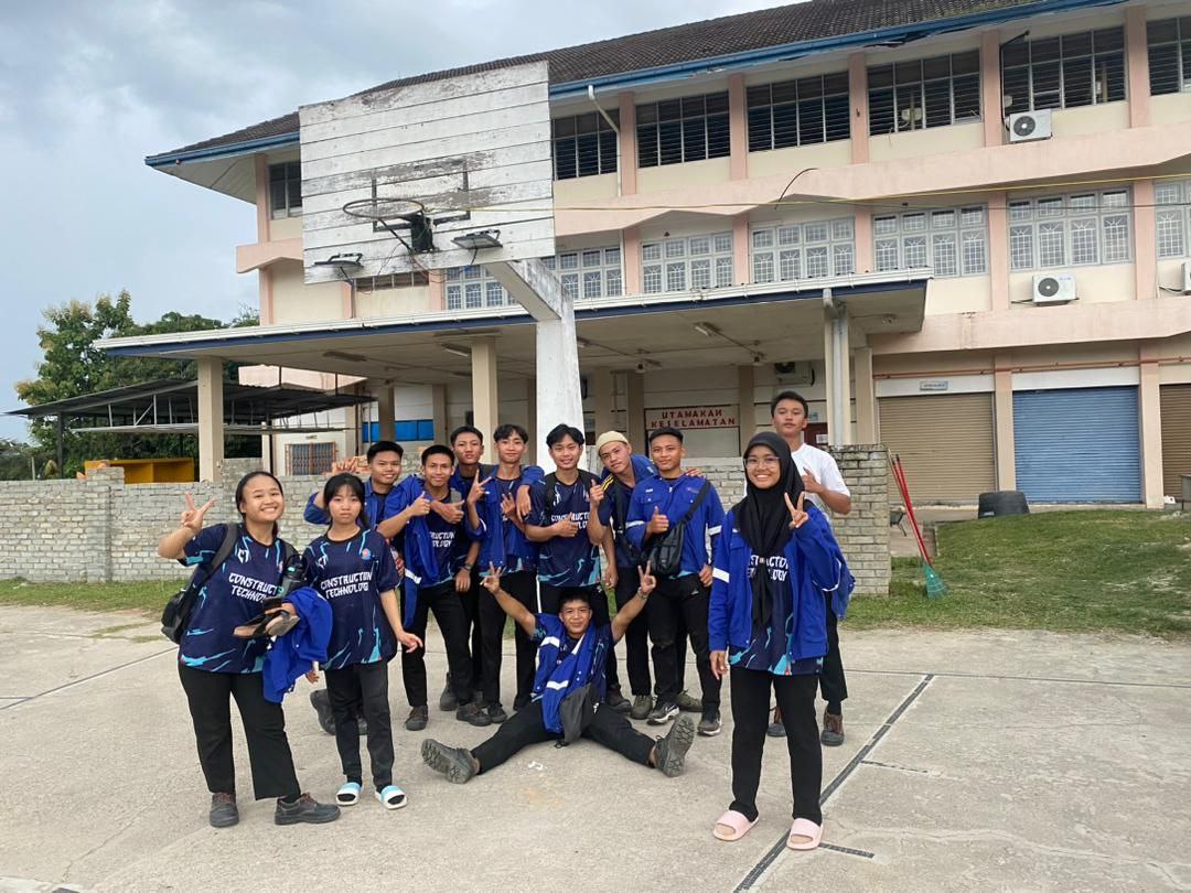 Students pose for a photo outside of their school.