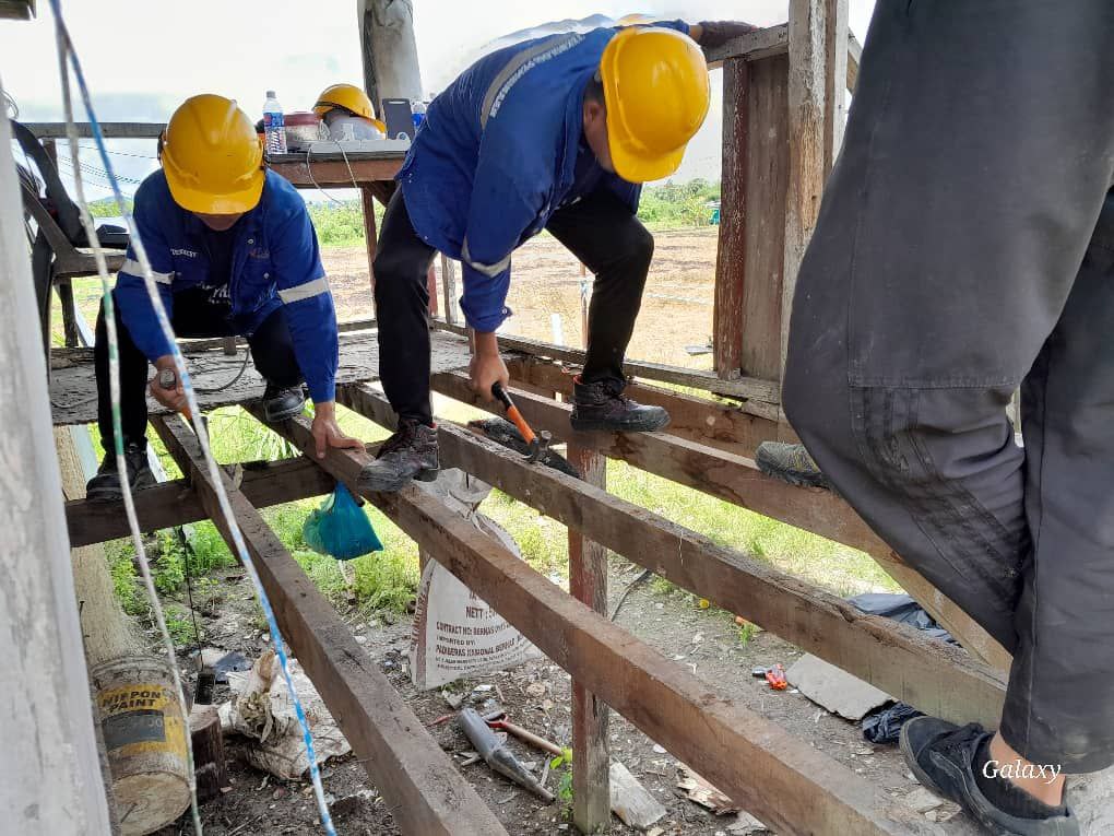 Students work on wooden beams for the porch. 