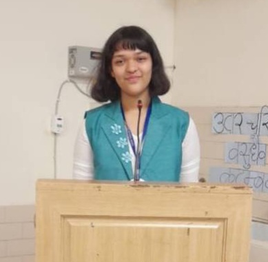 A student stands behind a podium