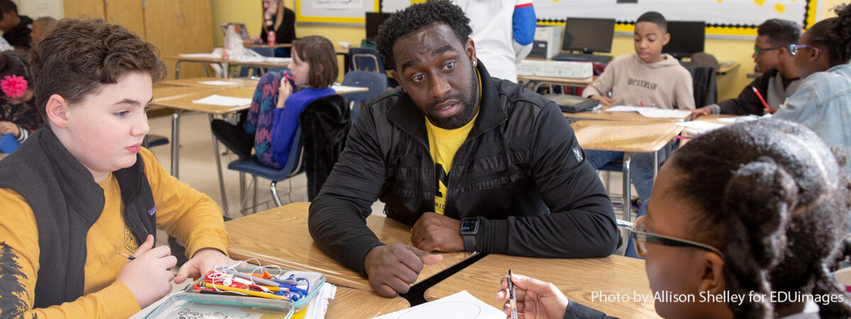 Three people sitting in a classroom setting.