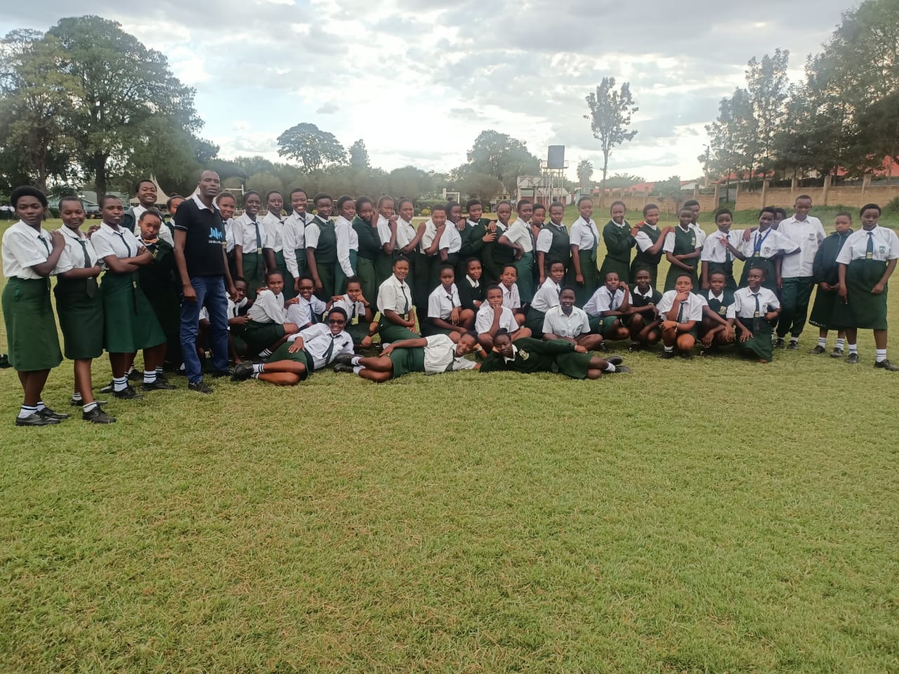 Dozens of students gather on a lawn for a group photo