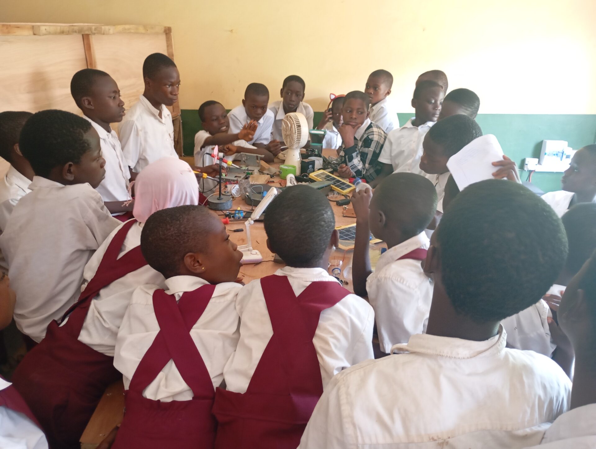 A large group of students gather around a table.