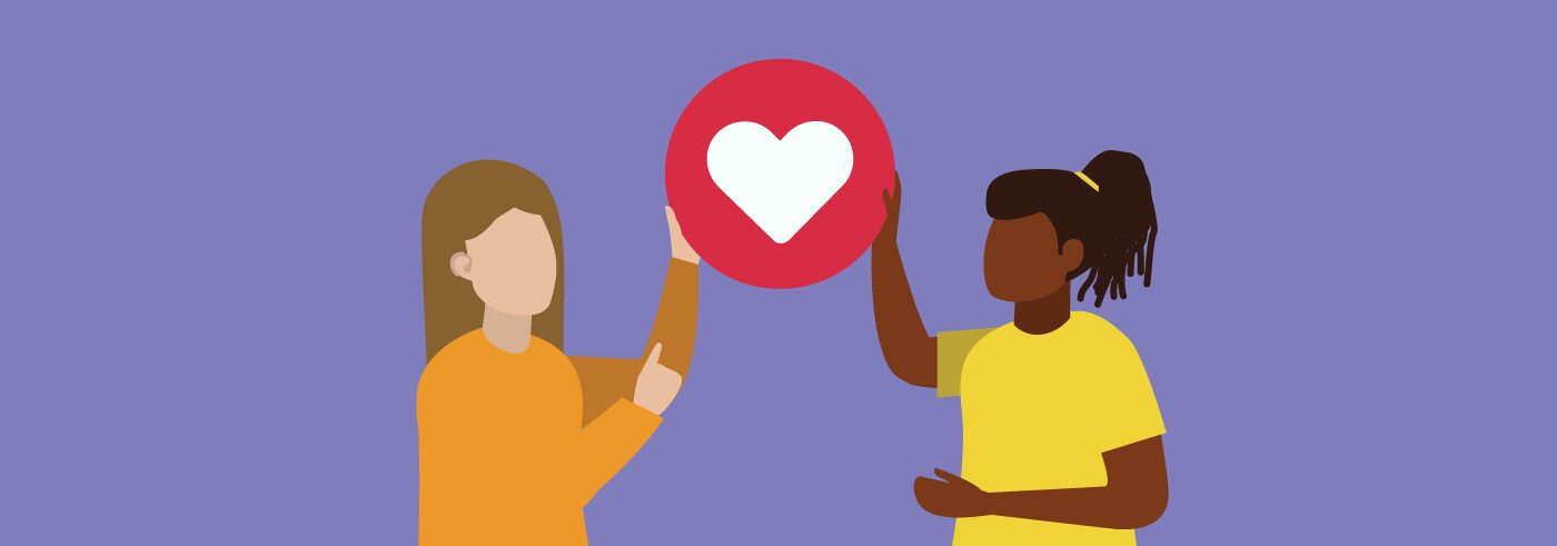 Two figures holding up a red heart between them.