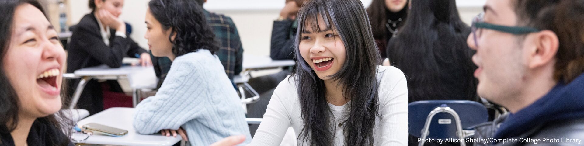 An image of high school students sitting at a table, talking and laughing. Photo by Allison Shelley for the Complete College Photo Library.