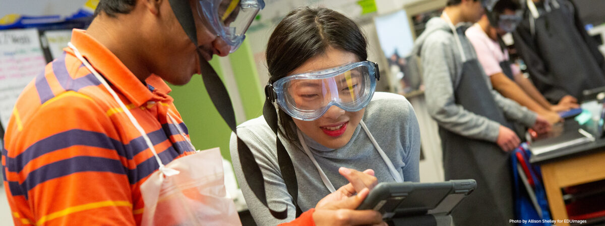High school students read their lab directions on a computer tablet during AP chemistry class.