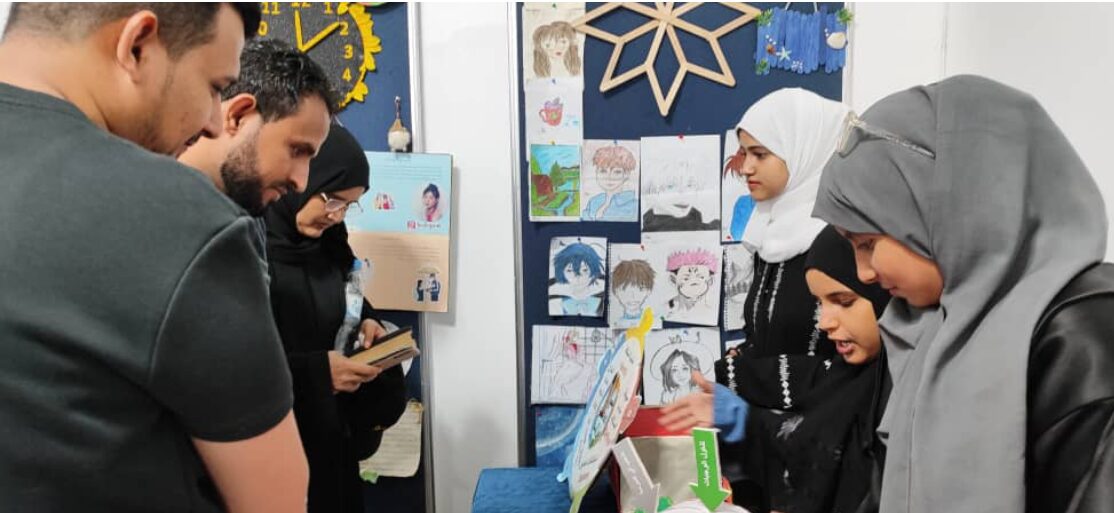 Teachers and students look at a gallery wall of student-created work