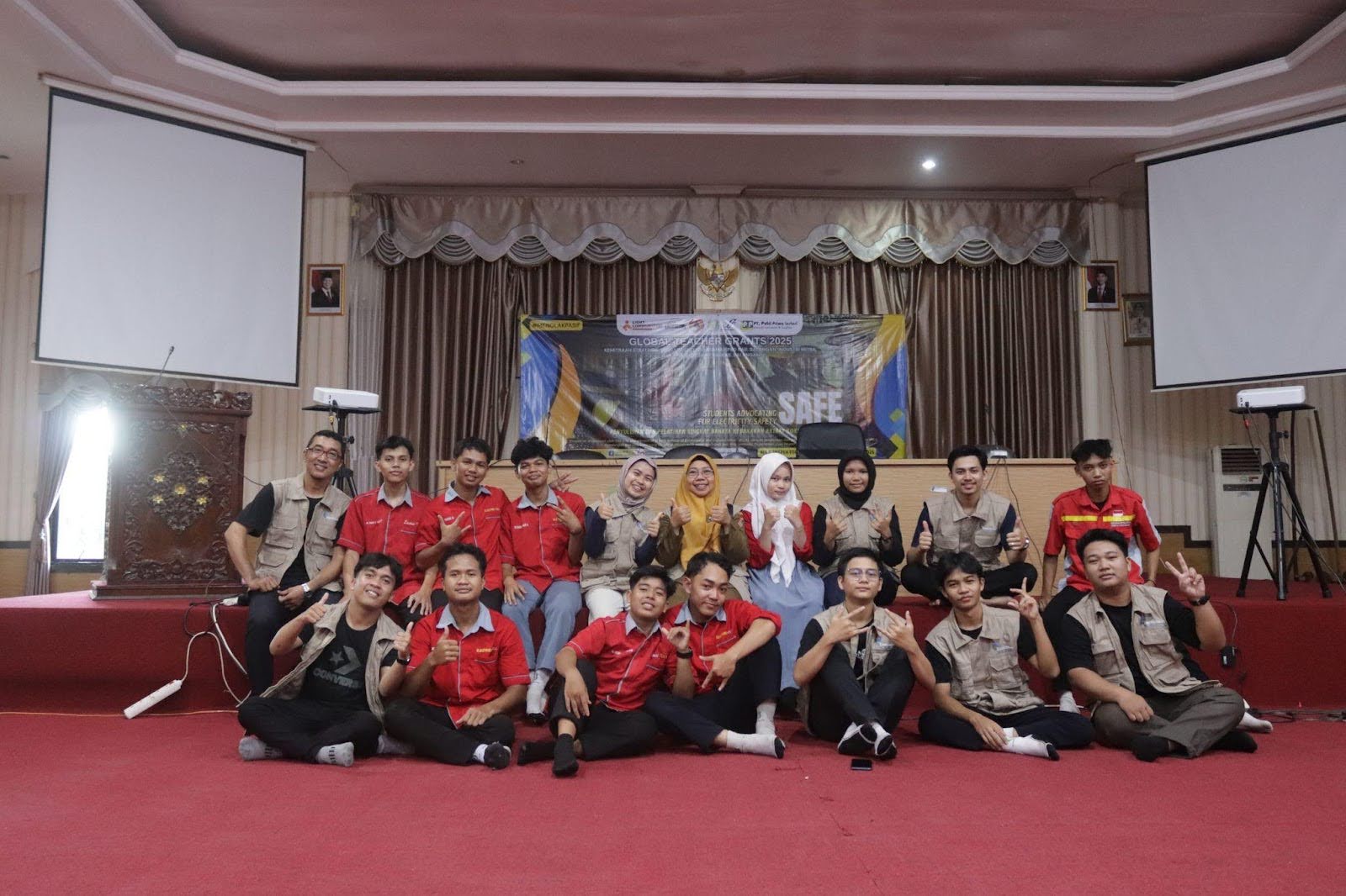 A large group of students and teachers pose for a picture in an auditorium. 