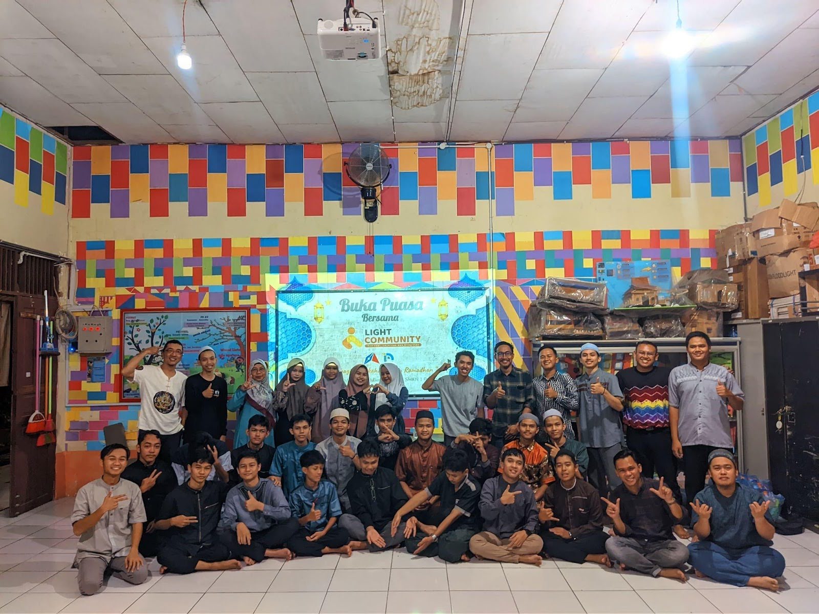 A large group of students and teachers pose for a photo in a classroom