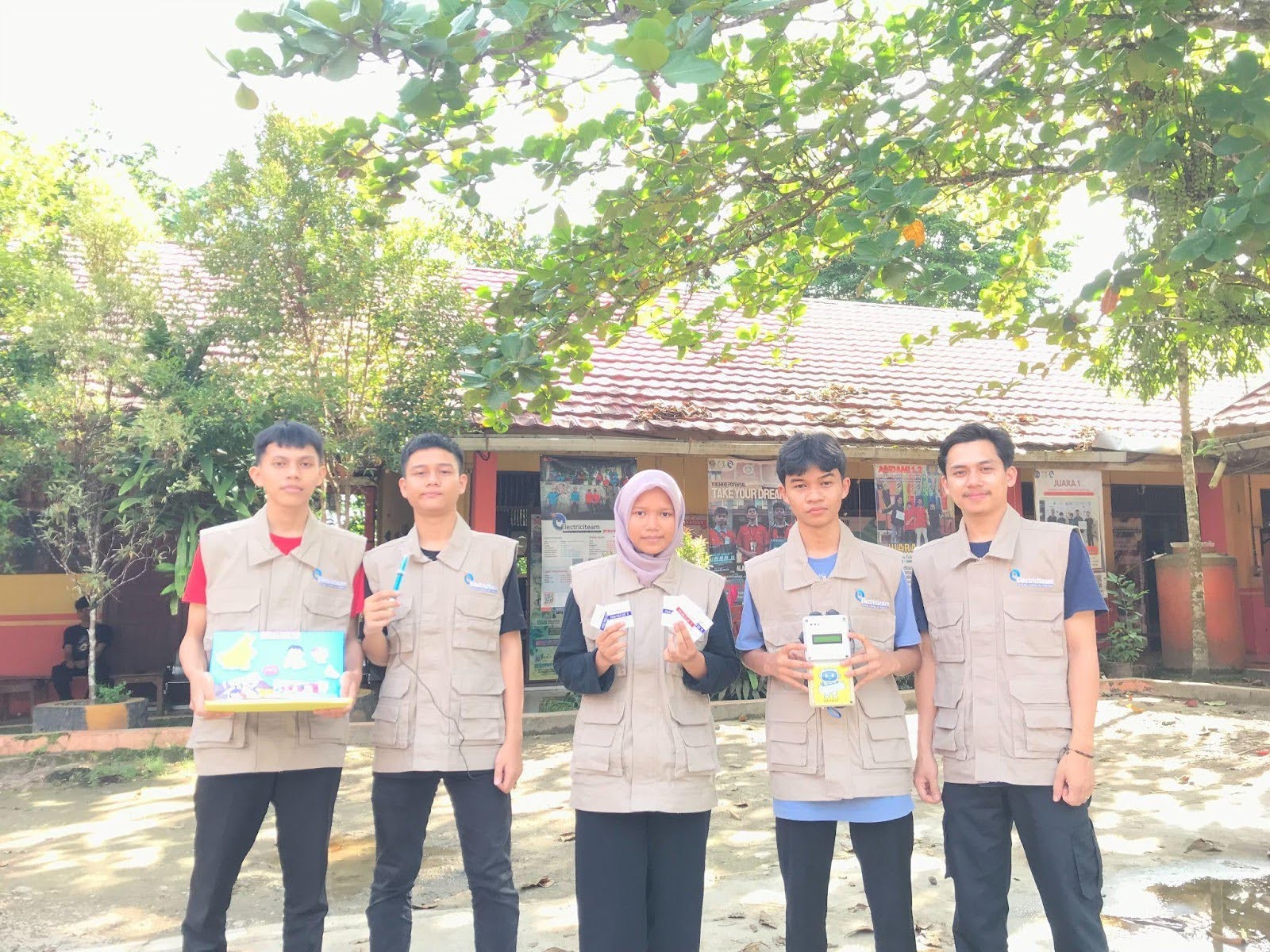 Five students pose for a photo with their devices.