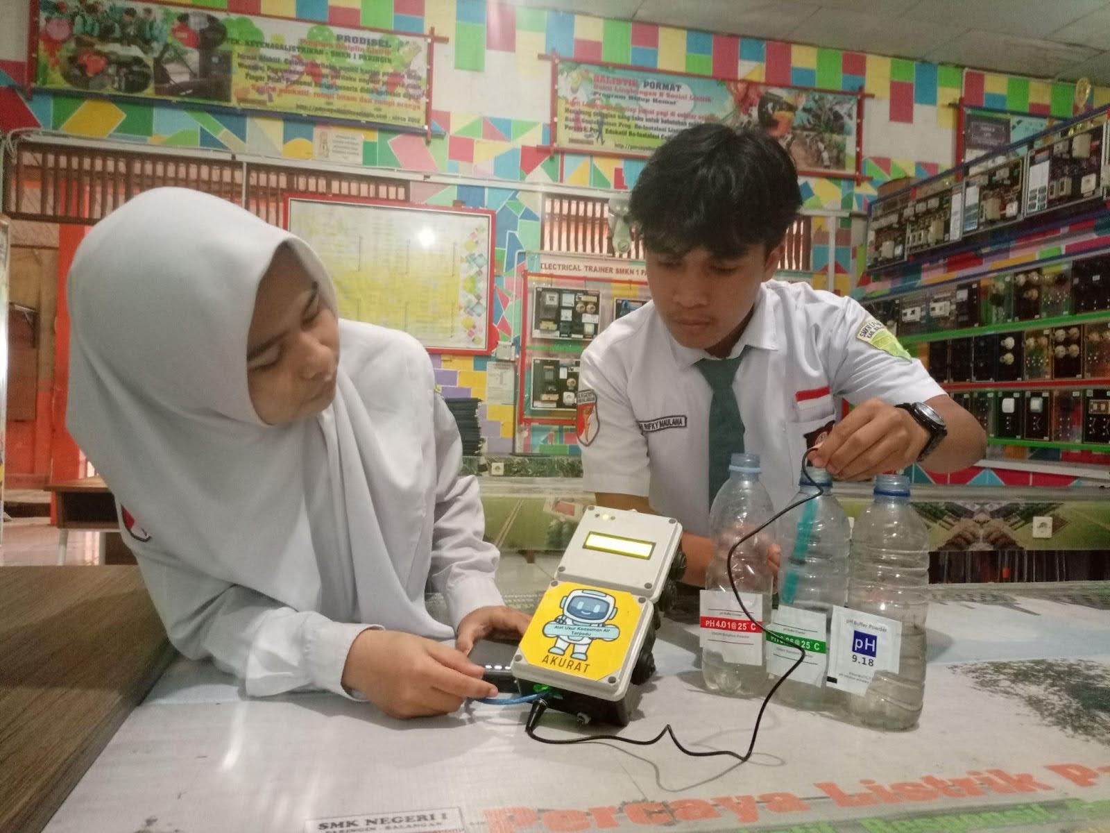 Two students connect devices they created for their project.