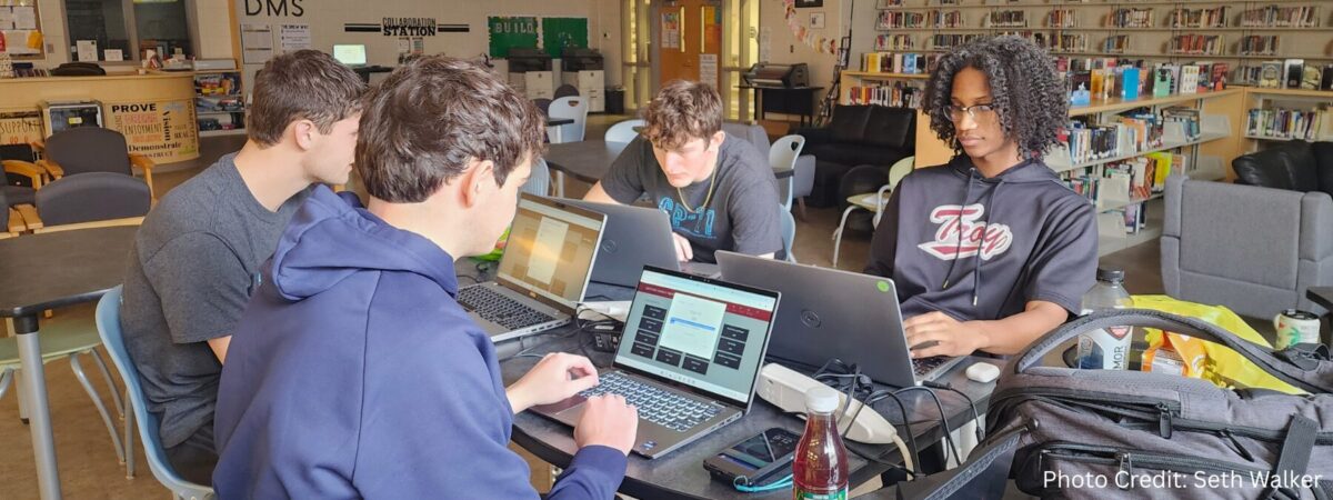 An image of student Seth Walker and his peers studying for their cybersecurity class at Lincoln High School in Talladega, AL.