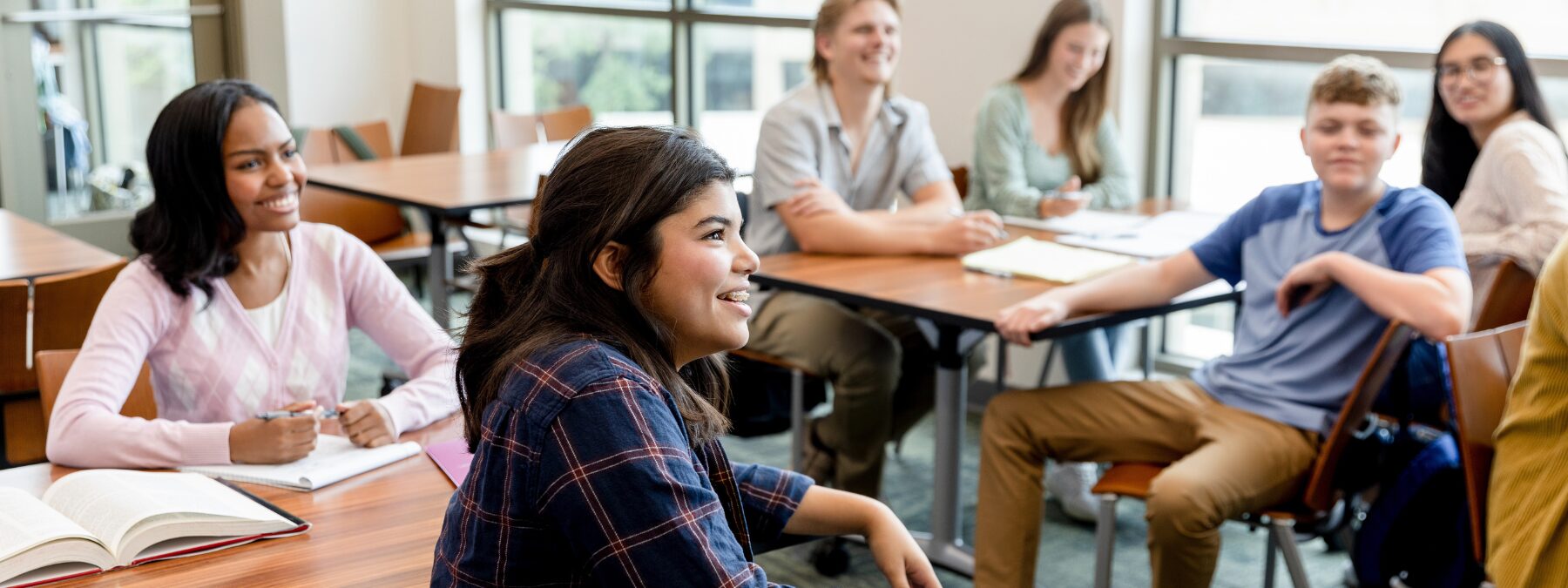 A group of students in a classroom looking at an educator off screen.