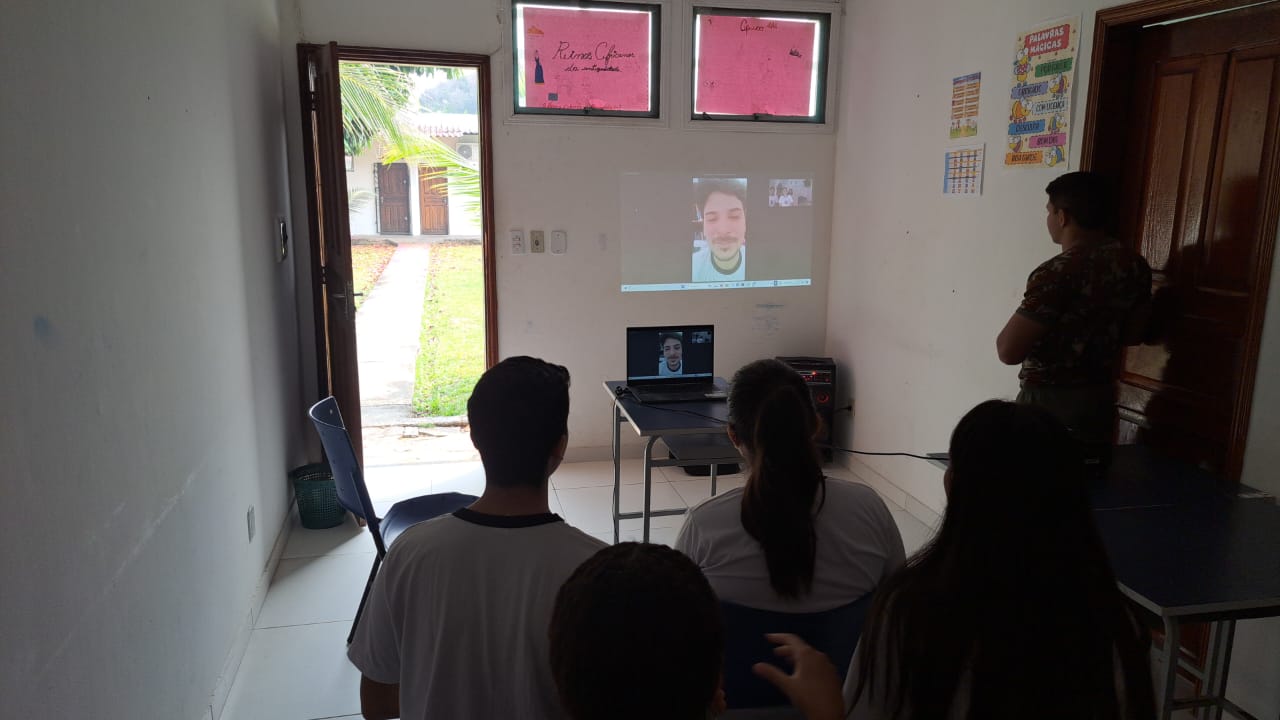 Students watch a projection of a Zoom meeting