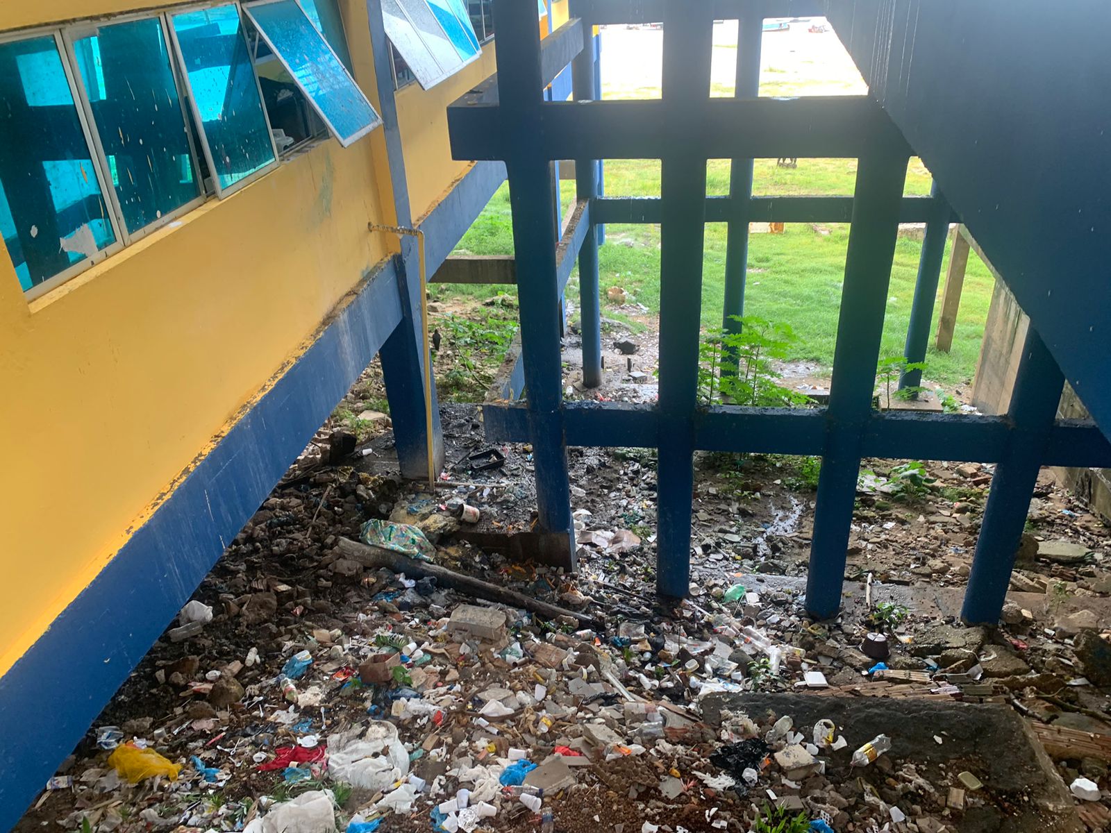 Litter piled underneath the stilts of a home
