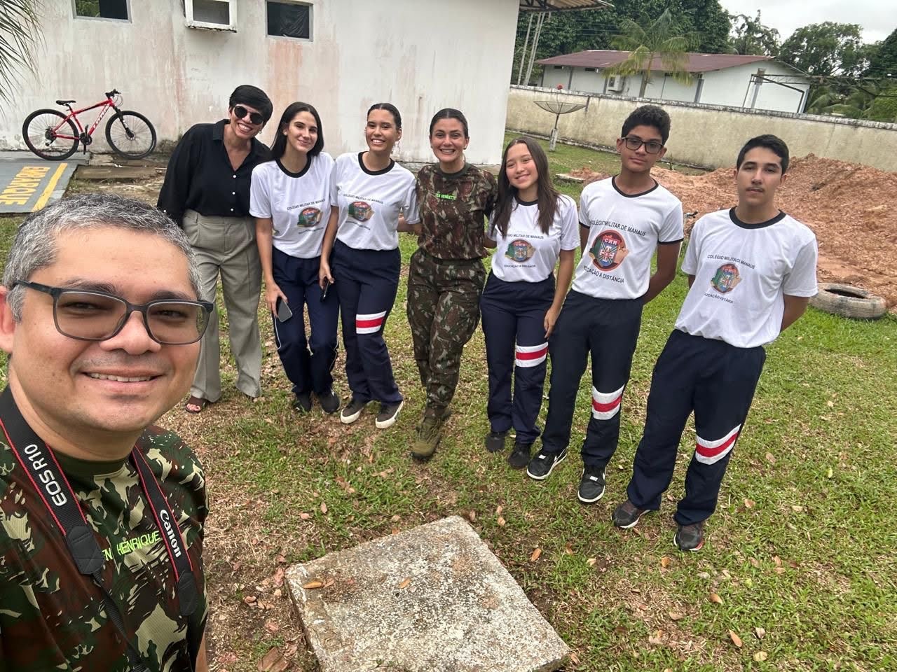 A selfie with the teacher and students behind him. 