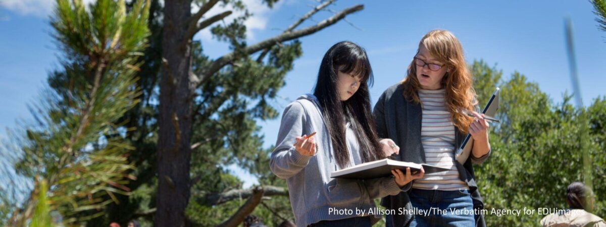 A teacher provides feedback on a student’s artwork.