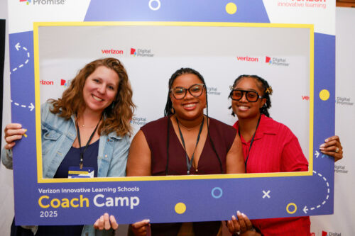 Three attendees pose with a “Verizon Innovative Learning Schools Coach Camp 2025” photo frame prop.