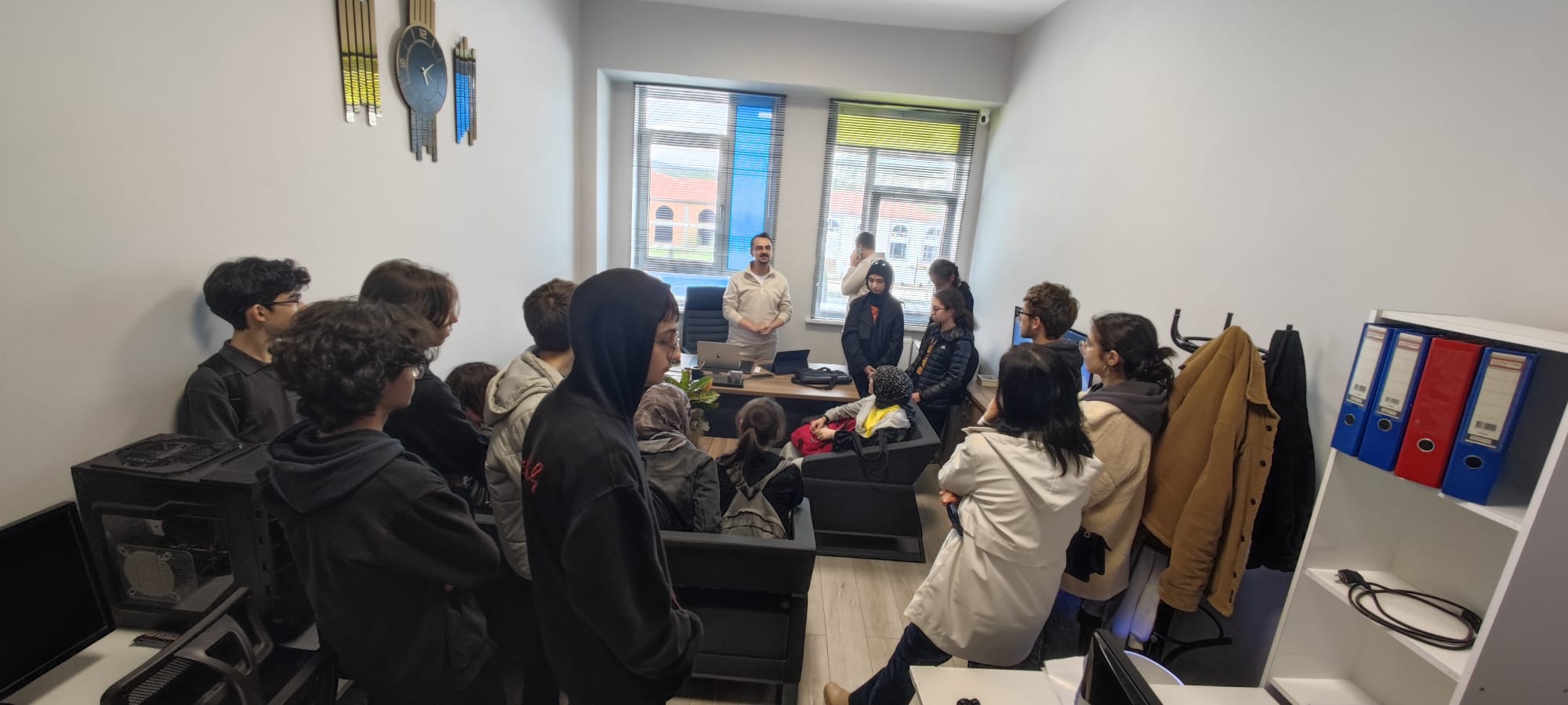 Students gather in a room with an adult mentor.
